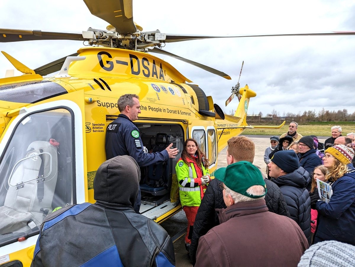 Air ambulance crew explaining their work to a group of motorcyclists.