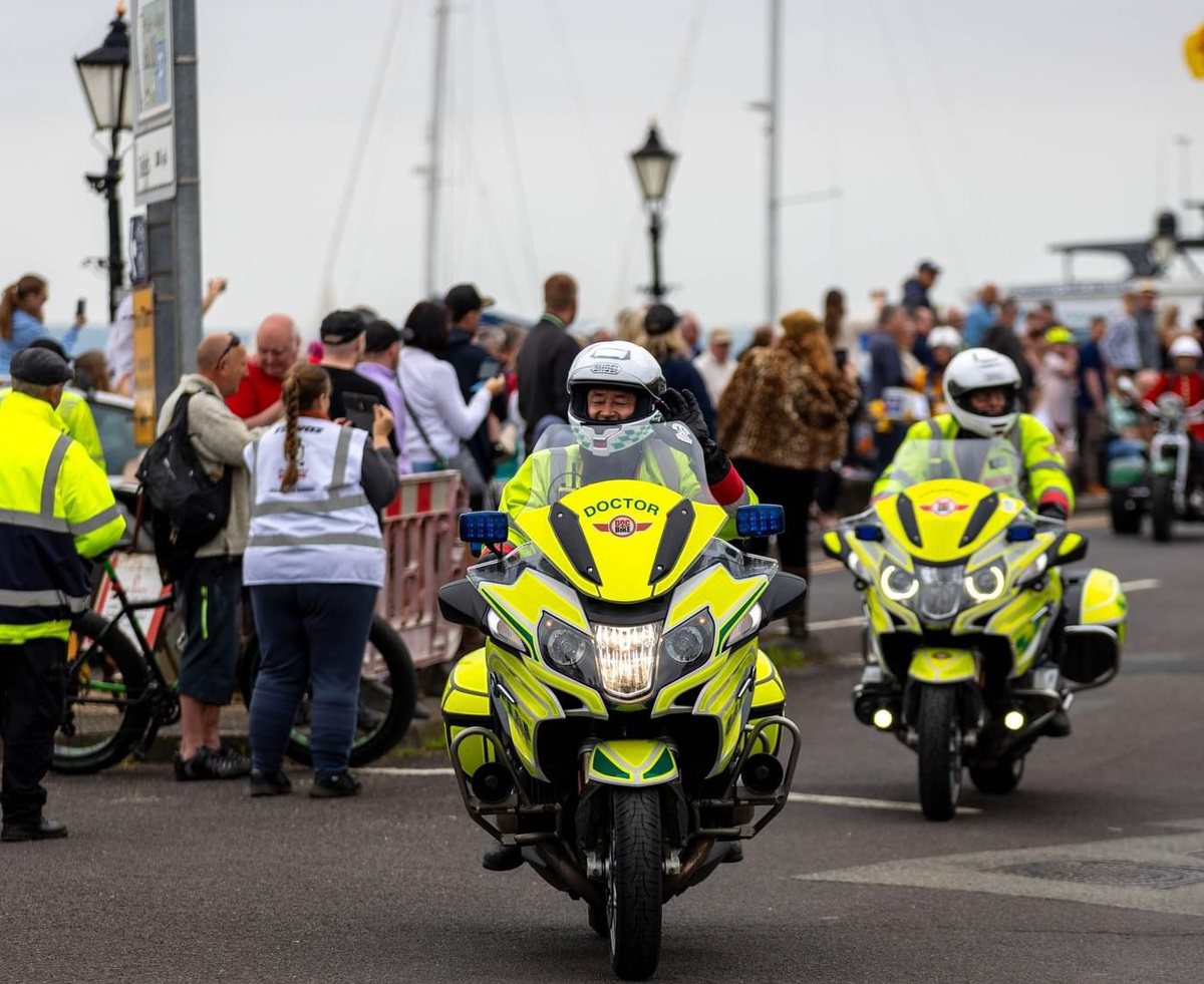 Two DocBike response motorcycles moving through a public event.