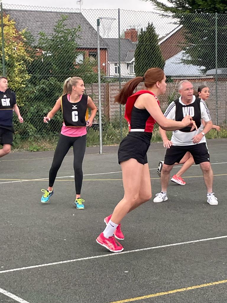 Group of women and men playing netball